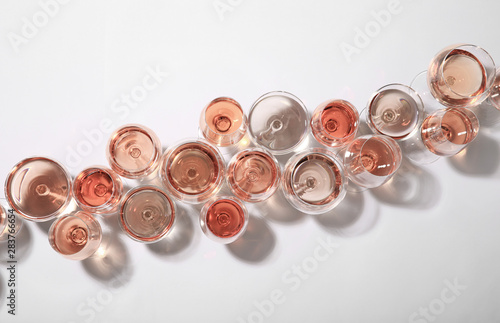 Different glasses with rose wine on white background, top view Slika na platnu