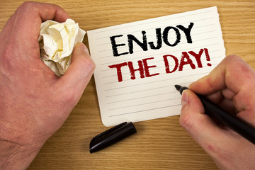 Handwriting text Enjoy The Day Motivational Call. Concept meaning Enjoyment Happy Lifestyle Relaxing Time Text two words white paper note black marker hand crumbled paper note