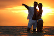© New Africa - Happy young couple spending time together on sea beach at sunset