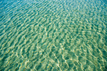 Tropical Blue-green Waters Background In Shallow Seas With Small Waves In Bright Sunlight