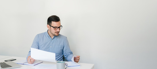 Thoughtful confident businessman checking working plan and schedule or timetable in office copy space