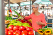 © Dragana Gordic - Senior woman on the market. Mature Female Customer Shopping At Farmers Market Stall.  Woman shopping at the local Farmers market. Beautiful senior woman buying vegetables.