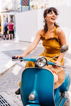 Smiling Woman In Yellow Dress Sitting On Vintage Blue Moped