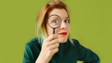 Search. A Young Woman With A Magnifying Glass Searches, Investigates And Studies.