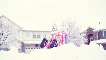 Fototapete - Slow motion. Little girl in pink hat playing in snow.