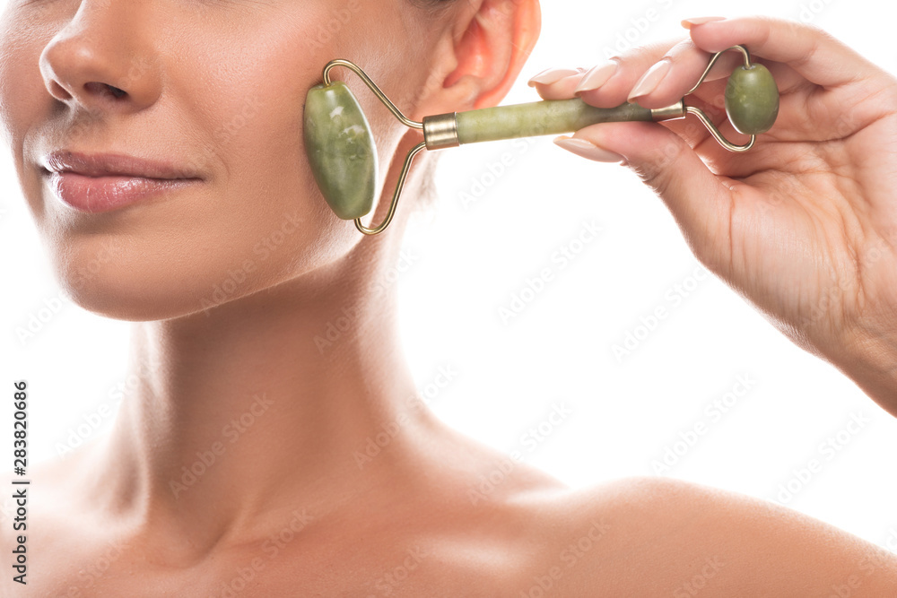 cropped view of naked young woman using facial jade roller and smiling isolated on white - obrazy, fototapety, plakaty 
