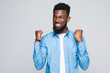 © F8  \ Suport Ukraine - Portrait of happy young african man looking camera make winner gesture standing isolated over white background.