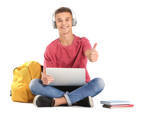 Portrait of young student with laptop showing thumb-up on white background