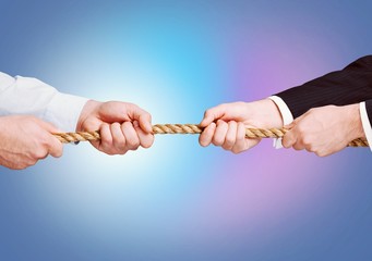 Tug war, two businessman pulling a rope in opposite directions isolated on white background