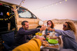 © simona - Happy people group of friends toasting and enjoying the travel vacation together - cheerful. womanandman with food in outdoor leisure activity - modern van and ocean in background