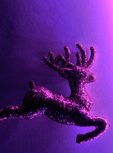 Christmas Glitter Deer On Violet Sparkling Background. Neon Light. Christmas Concept.