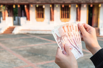 Cropped shot view of someone holding banknotes of Laos kip money (50,000 kip) the national currency of Laos.