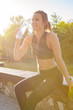 © fotofabrika - Young beautiful woman drinking water during morning jogging in the park