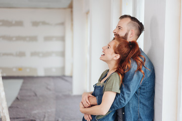 Laughing happy affectionate couple in a new home