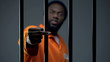 © motortion - Aggressive black prisoner showing medium finger, dangerous criminal imprisoned
