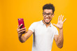 © denis_vermenko - Image of happy young african american man posing isolated over yellow background take a selfie by phone.
