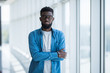 © F8  \ Suport Ukraine - Handsome African American man standing near panoramic windows in office center