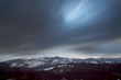 Long exposure of the snow-covered mountains and a cloudy sky.