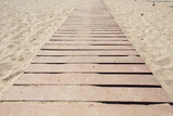 Fototapeta Na drzwi - Wooden walking path along sandy shore. beach path