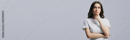 Fotomural serious thoughtful beautiful girl in white t-shirt looking away isolated on grey