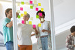 © WavebreakMediaMicro - Business people discussing over sticky notes in the office