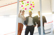 © WavebreakMediaMicro - Business people discussing over sticky notes in the office