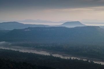  Mountain view morning of Peak mountain above mekong river around with soft mist and cloudy sky background, sunrise at Cha Na Dai Cliff, Pha Taem National Park, Ubon Ratchathani, Thailand.