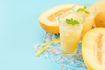 sweet and cold juice from melon in glasses against the background of melon sliced