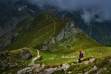 Woman hiking into rocky mountains