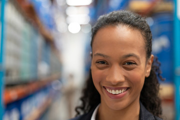 Female manager looking at camera in warehouse