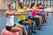 © WavebreakMediaMicro - Fit people performing yoga on exercise ball in fitness center
