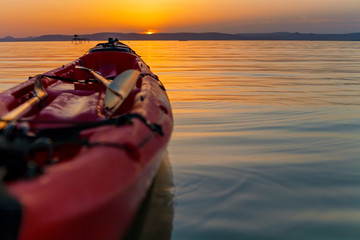 Canvas Print - Sunset over lake Balaton with a red kayak in the front