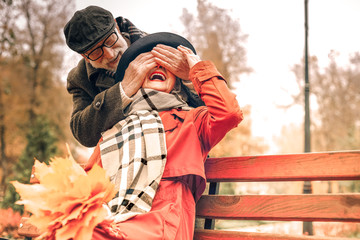 Sweet old man surprising his wife in park