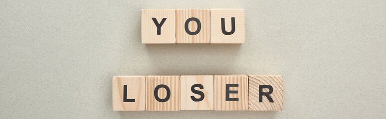 Wall Mural - panoramic shot of wooden blocks with you loser lettering on grey background, bullying concept