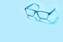 Blue Square Glasses On Blue Background With Copy Space For Text. Colorful Eyeglasses.