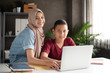 © Watcharin - The muslim woman teaching young boy for using laptop,two students doing activity together,at school,blurry light around