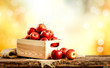 Red apples on the wooden table and blurred autumn background.