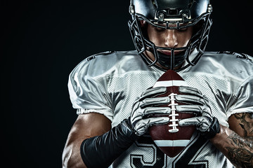 Wall Mural - American football sportsman player in helmet isolated run in action on black background. Sport and motivation wallpaper. Team sports,