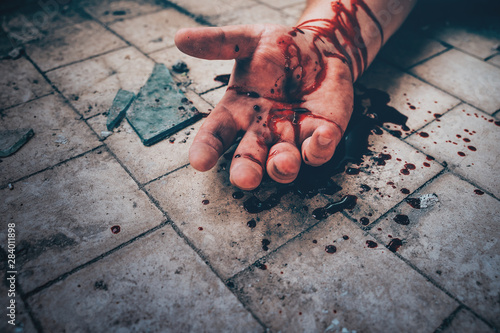 Fotomural Crime scene with human hand in blood on floor of killed man by murder, dead body part close up