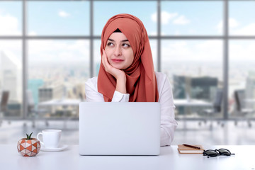 Canvas Print - Muslim woman working with computer in office, hijab muslim girl confused