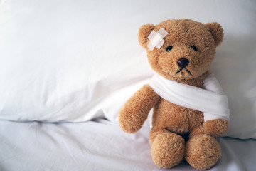 teddy bear and bandage. injury concept