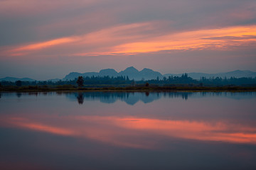 Wall Mural - Beautiful sunrise with red sky and reflection in the lake...