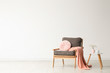 © New Africa - Stylish living room interior with comfortable armchair and wooden table near white wall. Space for text