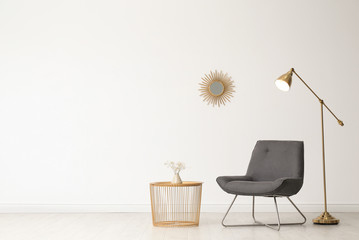 Poster - stylish living room interior with comfortable chair and side table near white wall. space for text