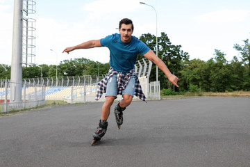 Canvas Print - Handsome young man roller skating outdoors. Recreational activity