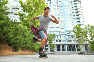 Poster - Handsome young man roller skating outdoors. Recreational activity