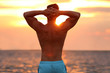 © New Africa - Handsome young man posing on beach near sea at sunset