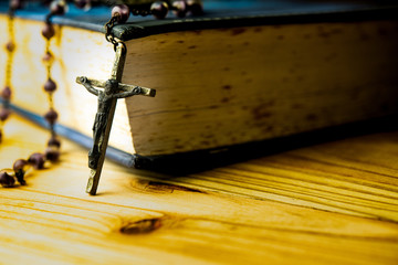 Wall Mural - Closeup Catholic rosary beads with crucifix on wooden background.