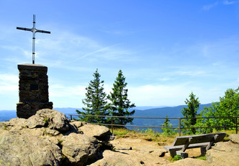 Wall Mural - cross and wooden bench on the summit of a mount grosser falkenstein in the national park bayerische 