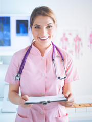 Woman doctor standing with folder at hospital